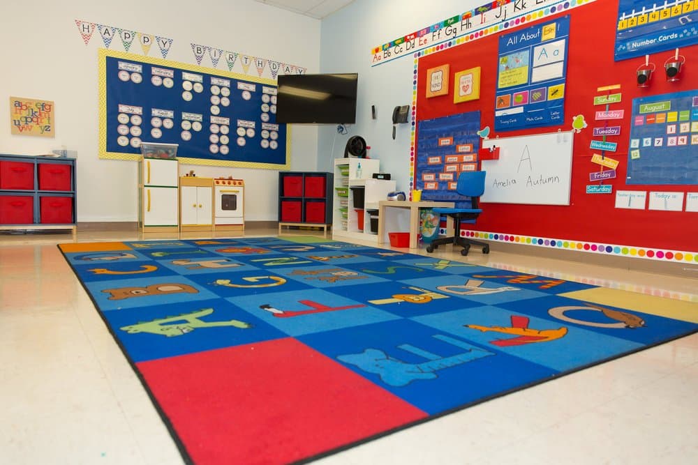 A bright, colorful Wilkins classroom with alphabet learning rug